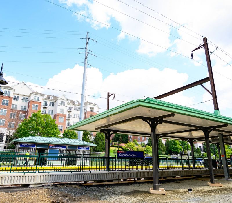 Madison West Elm apartments Outdoor train station platform under construction with apartment buildings in the background.
